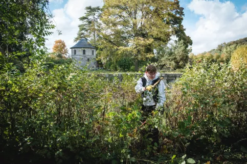 Un jeune en formation en train de travailler dans les jardins du campus