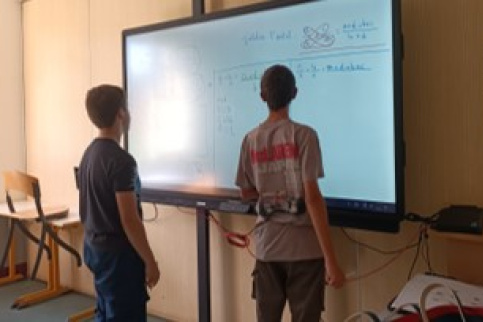 les jeunes inscrits à la remédiation scolaire font un exercice sur le tableau numérique