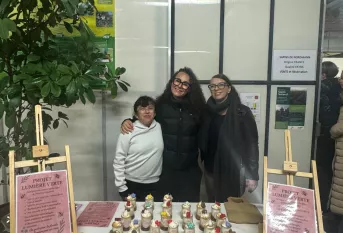 deux élèves et leur éducatrice posent devant les bougies qu'elles ont fabriquées