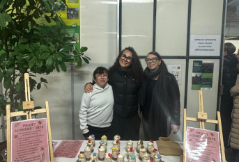 deux élèves et leur éducatrice posent devant les bougies qu'elles ont fabriquées