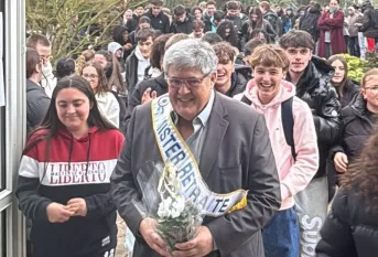Denis Dugord entre dans le forum accompagné des jeunes. il porte une écharpe "mister retraite"
