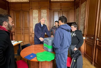 les jeunes éco-responsables et leurs enseignants présentent à M. Albert leur projet. Ils sont tous dans le bureau du directeur et discutent ensemble.