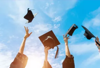 chapeau de jeunes diplomés lancés dans le ciel bleu