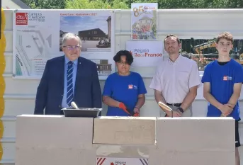 les officiels et 2 jeunes de 4ème posent devant la 1ère pierre du nouveau batiment des classes