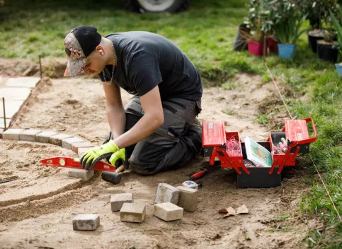 Jeune à genoux travaillant sur une scène paysagère