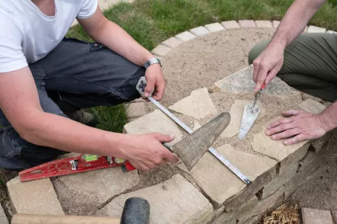 Un jeune et son professeur en travaux paysagers avec des outils