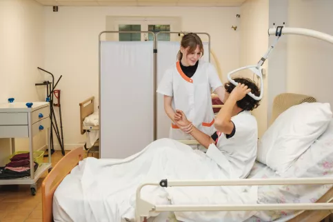 Deux jeunes en formation dans une chambre avec un lit médicalisé