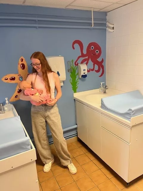 Noémie tient un bébé dans ses bras en salle de soins