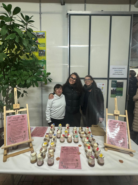 deux élèves et leur éducatrice posent devant les bougies qu'elles ont fabriquées