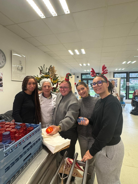 les jeunes, dans une ambiance festive et de Noel, sont à la cantine du Campus Saint-Antoine. Ils encouragent les personnes qui trient leurs déchets.