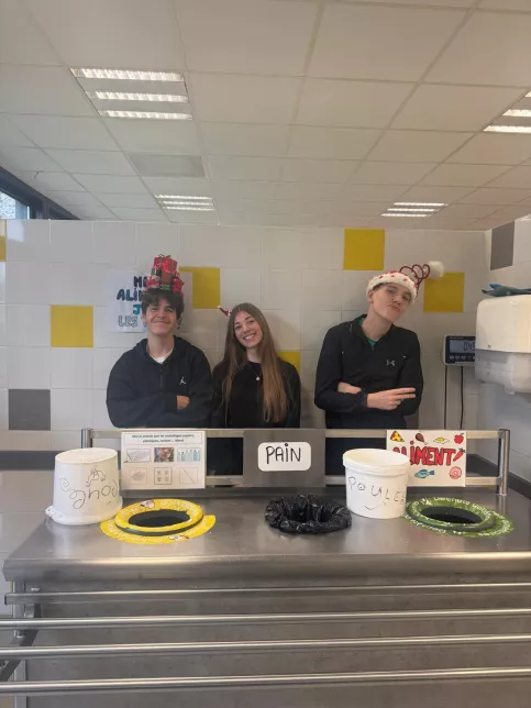 les jeunes, dans une ambiance festive et de Noel, sont à la cantine du Campus Saint-Antoine. Ils encouragent les personnes qui trient leurs déchets.