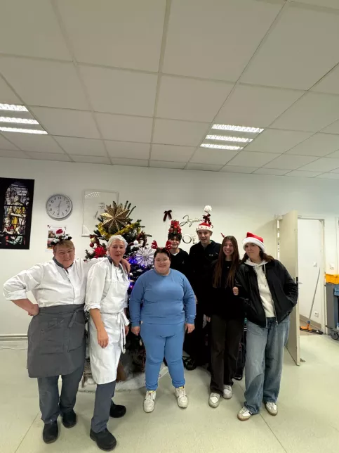 les jeunes, dans une ambiance festive et de Noel, sont à la cantine du Campus Saint-Antoine. Ils encouragent les personnes qui trient leurs déchets.