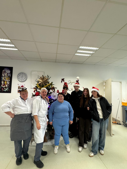 les jeunes, dans une ambiance festive et de Noel, sont à la cantine du Campus Saint-Antoine. Ils encouragent les personnes qui trient leurs déchets.
