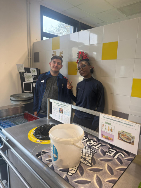 les jeunes, dans une ambiance festive et de Noel, sont à la cantine du Campus Saint-Antoine. Ils encouragent les personnes qui trient leurs déchets.