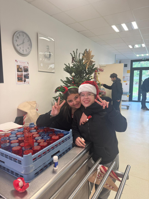 les jeunes, dans une ambiance festive et de Noel, sont à la cantine du Campus Saint-Antoine. Ils encouragent les personnes qui trient leurs déchets.