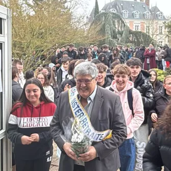 Denis Dugord entre dans le forum accompagné des jeunes. il porte une écharpe "mister retraite"
