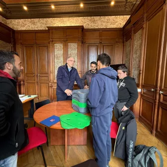 les jeunes éco-responsables et leurs enseignants présentent à M. Albert leur projet. Ils sont tous dans le bureau du directeur et discutent ensemble.