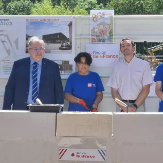 les officiels et 2 jeunes de 4ème posent devant la 1ère pierre du nouveau batiment des classes