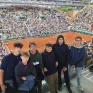 les jeunes du projet tennis sont spectateurs d'un match de tennis à Roland Garros. Ils posent devant un terrain en terre battue.